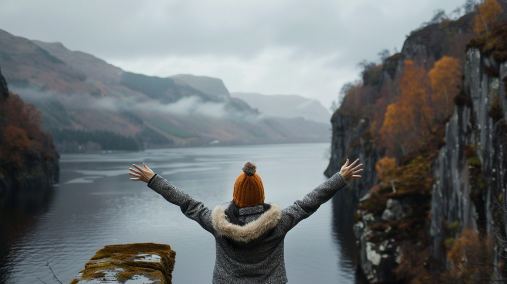 A hiker near Loch Ness gazing at cliffs, embracing Scotland's natural beauty.